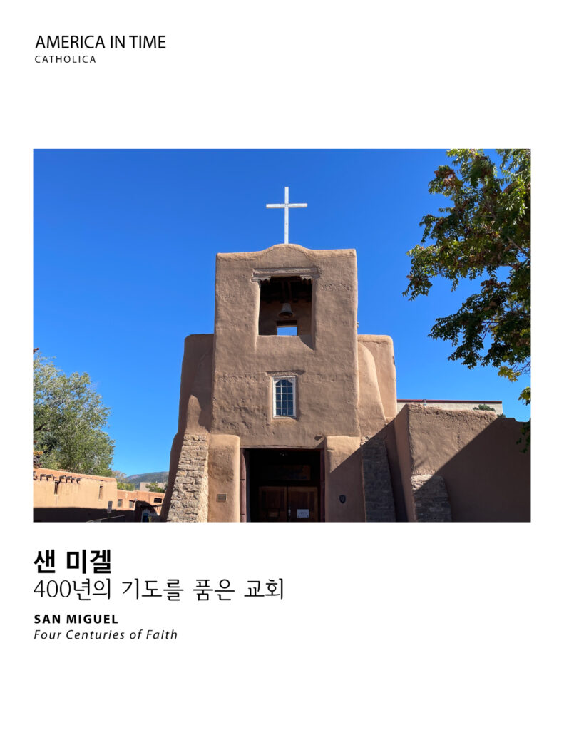 San Miguel adobe church in Santa Fe, New Mexico, with its bell tower and white cross against a blue sky.